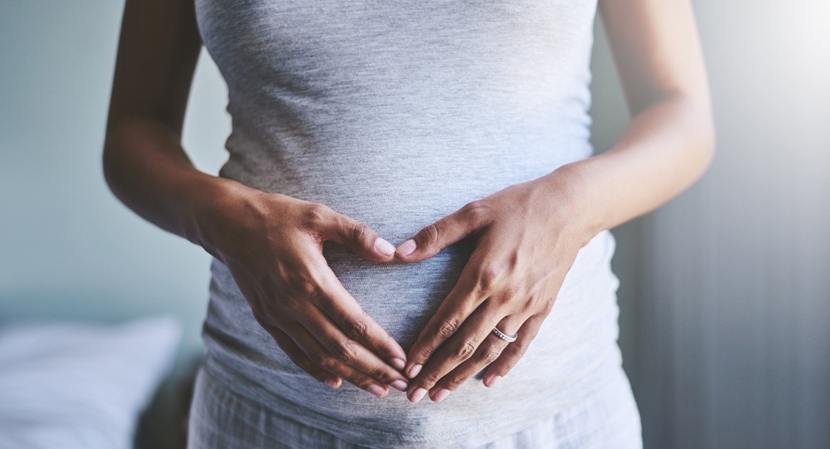 Pregnant woman with her hands on her belly